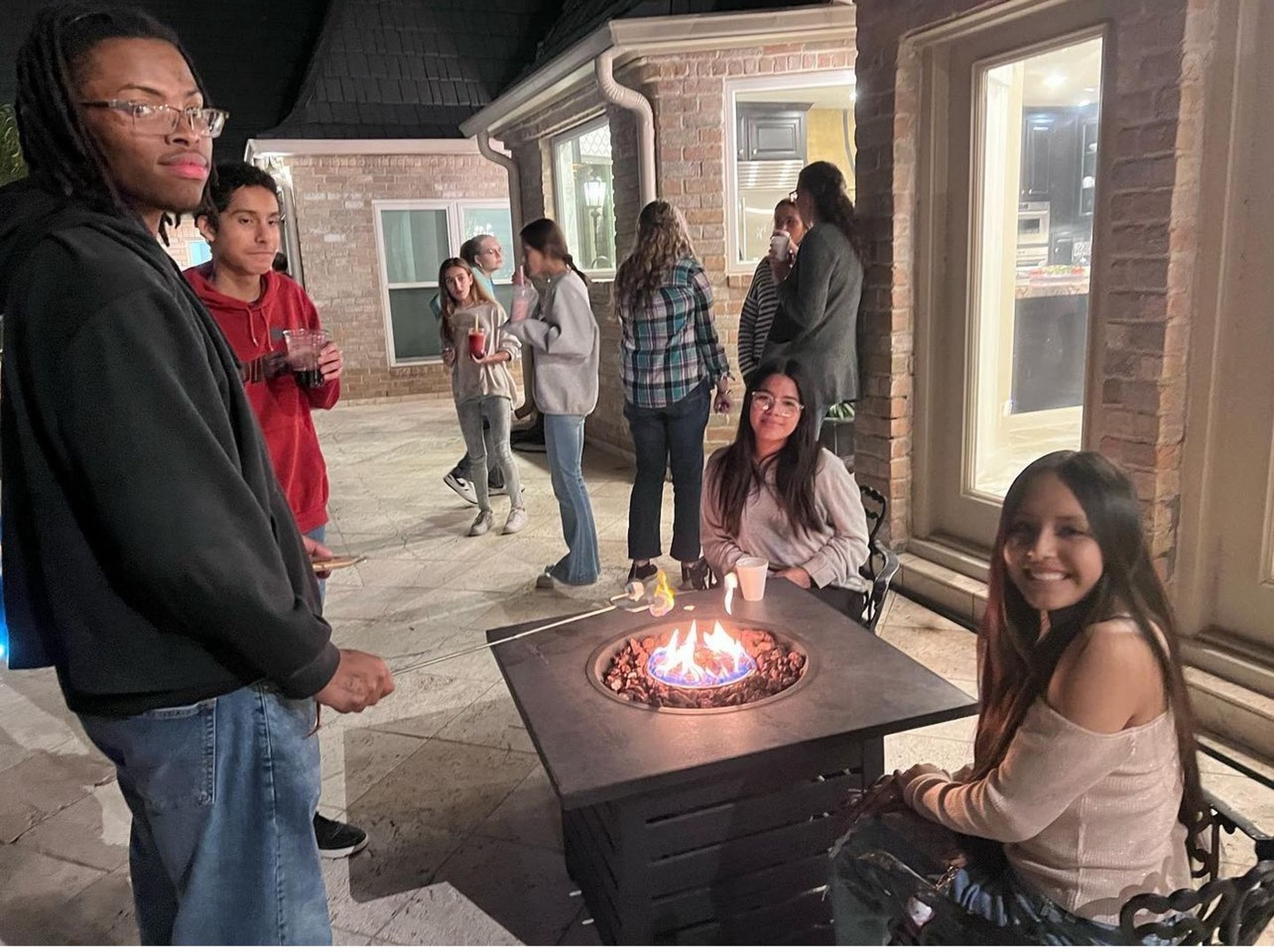 YAF Houston students gathered around a fire pit at night