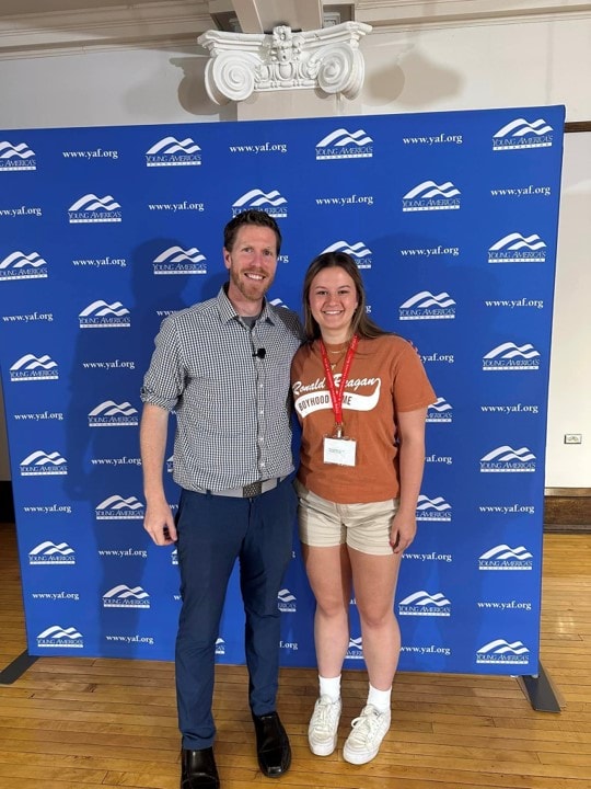 YAF Houston student with speaker at a YAF backdrop event