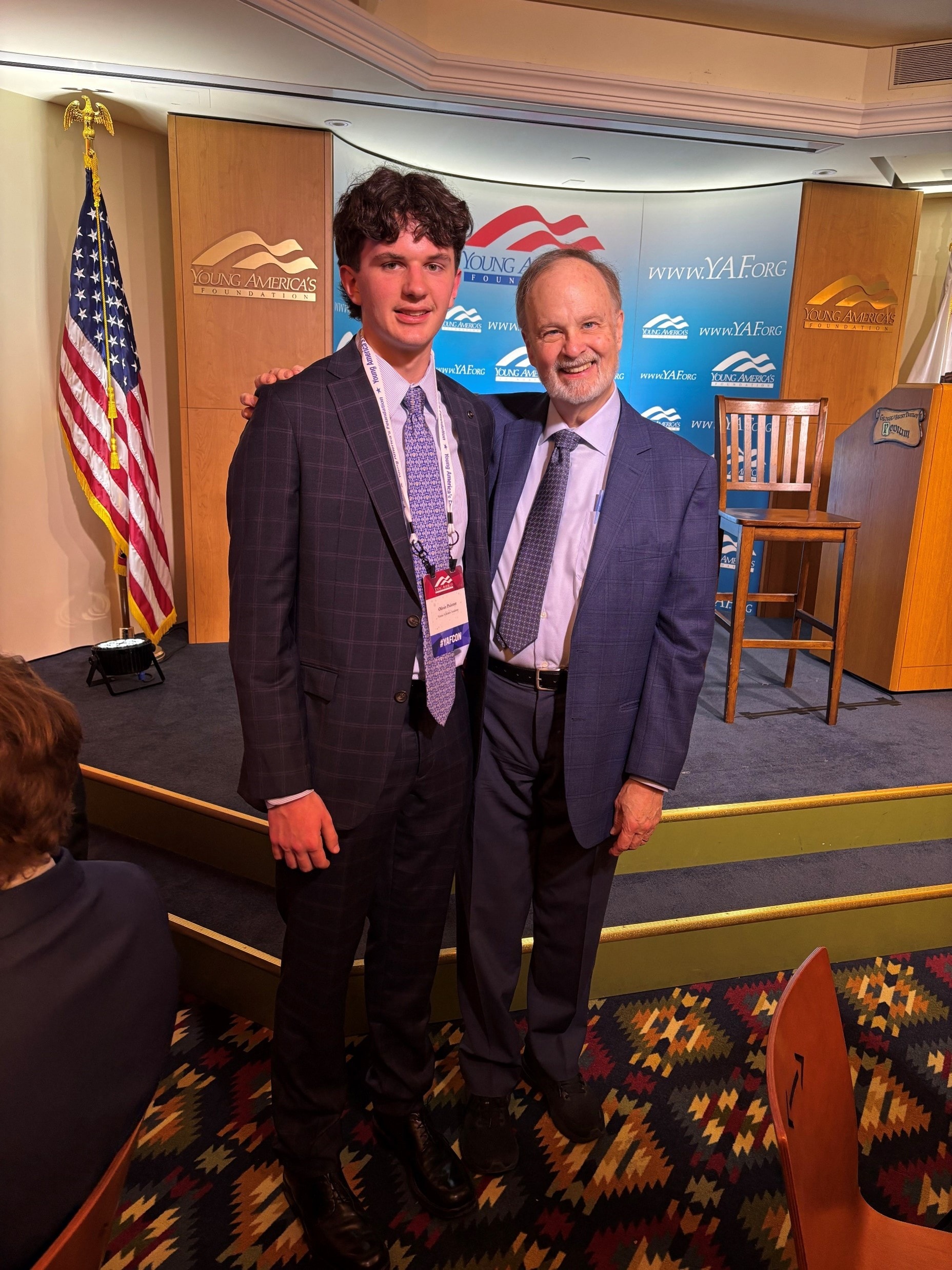 YAF Houston student with speaker at a YAF conference podium