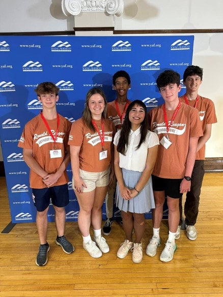 YAF Houston students in Ronald Reagan Boyhood Home shirts at a YAF backdrop