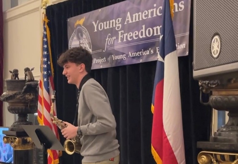 YAF Houston student performing the national anthem on saxophone at a YAF event