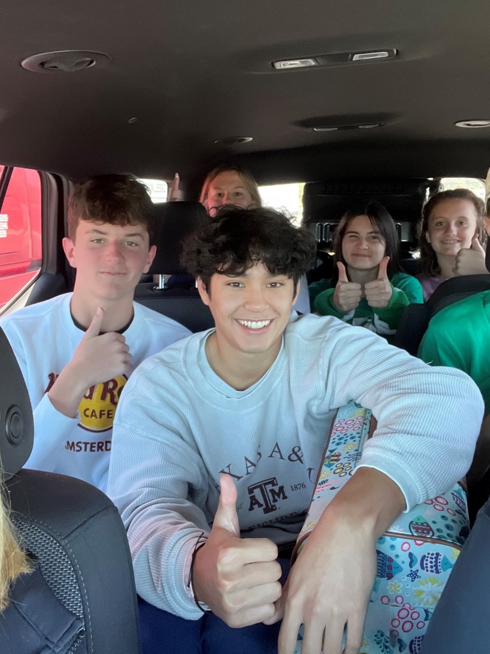 YAF Houston students giving thumbs up in the van on the way to Reagan Ranch